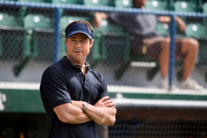 "Die Kunst zu gewinnen - Moneyball": Billy Beane (Brad Pitt) steht mit verschränkten Armen am Spielfeldrand und schaut ernst in die Ferne.