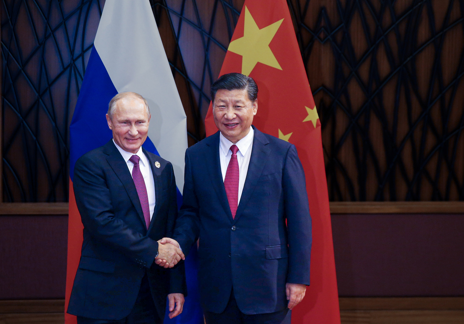 "ZDFzeit: Putin und Xi - Pakt gegen den Westen": Wladimir Putin und Xi Jinping stehen vor der russischen und der chinesischen Fahne und geben sich die Hand.