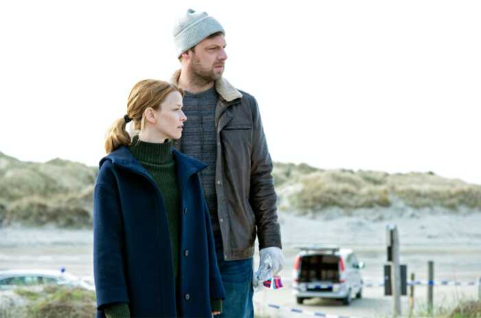 "Die Toten am Meer": Ria Larsen (Karoline Schuch) und Michael Brandt (Christoph Letkowski) stehen nebeneinander am Strand. Im Hintergrund ist ein Polizeiwagen zu sehen.