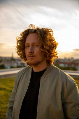 Michael Schulte steht vor einer untergehenden Sonne.