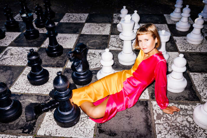 Portraitfoto Caroline Wahl auf einem Schachbrett – ihr Debütroman „22 Bahnen“ wurde als Lieblingsbuch der unabhängigen Buchhandlungen 2023 ausgezeichnet