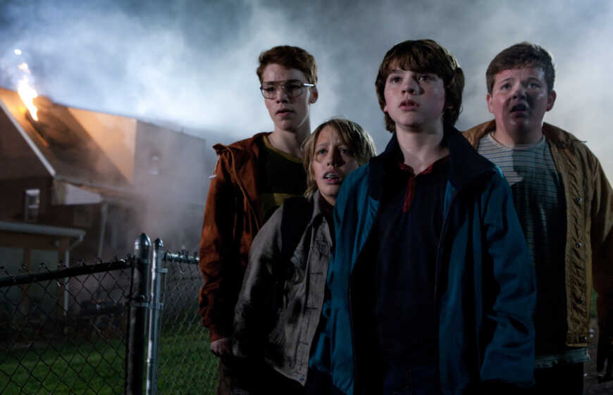 "Super 8": Martin (Gabriel Basso), Cary (Ryan Lee), Joe (Joel Courtney) und Charles (Riley Griffiths) stehen vor einer dichten Nebelwand neben einem entgleisten Zug.