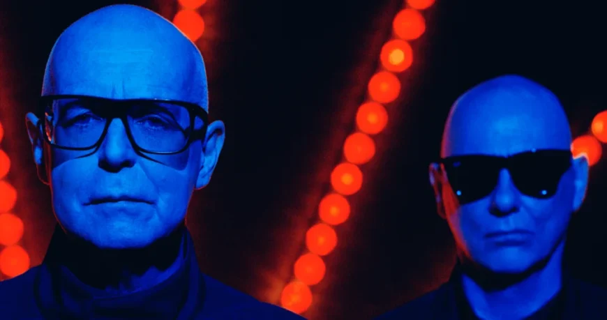 Pet Shop Boys Pressefoto. Zu sehen sind die beiden Bandmitglieder, Neil Tennant und Chris Low, im Portrait fotografiert, in blaues und oranges Licht getaucht.