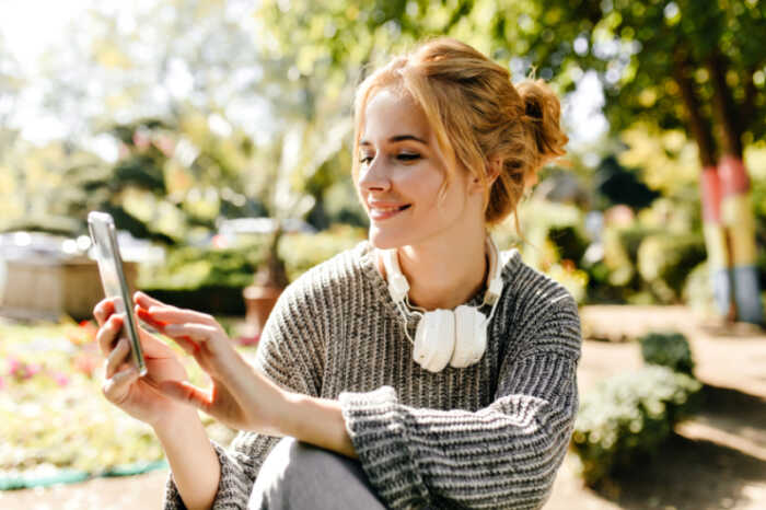 frau-die-im-gewaechshaus-sitzt-nimmt-selfie-auf-ihrem-telefon