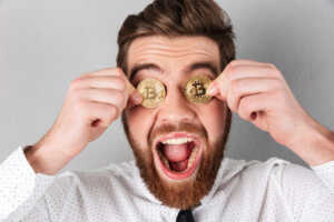 close-up-joyful-businessman-with-bitcoins-his-eyes