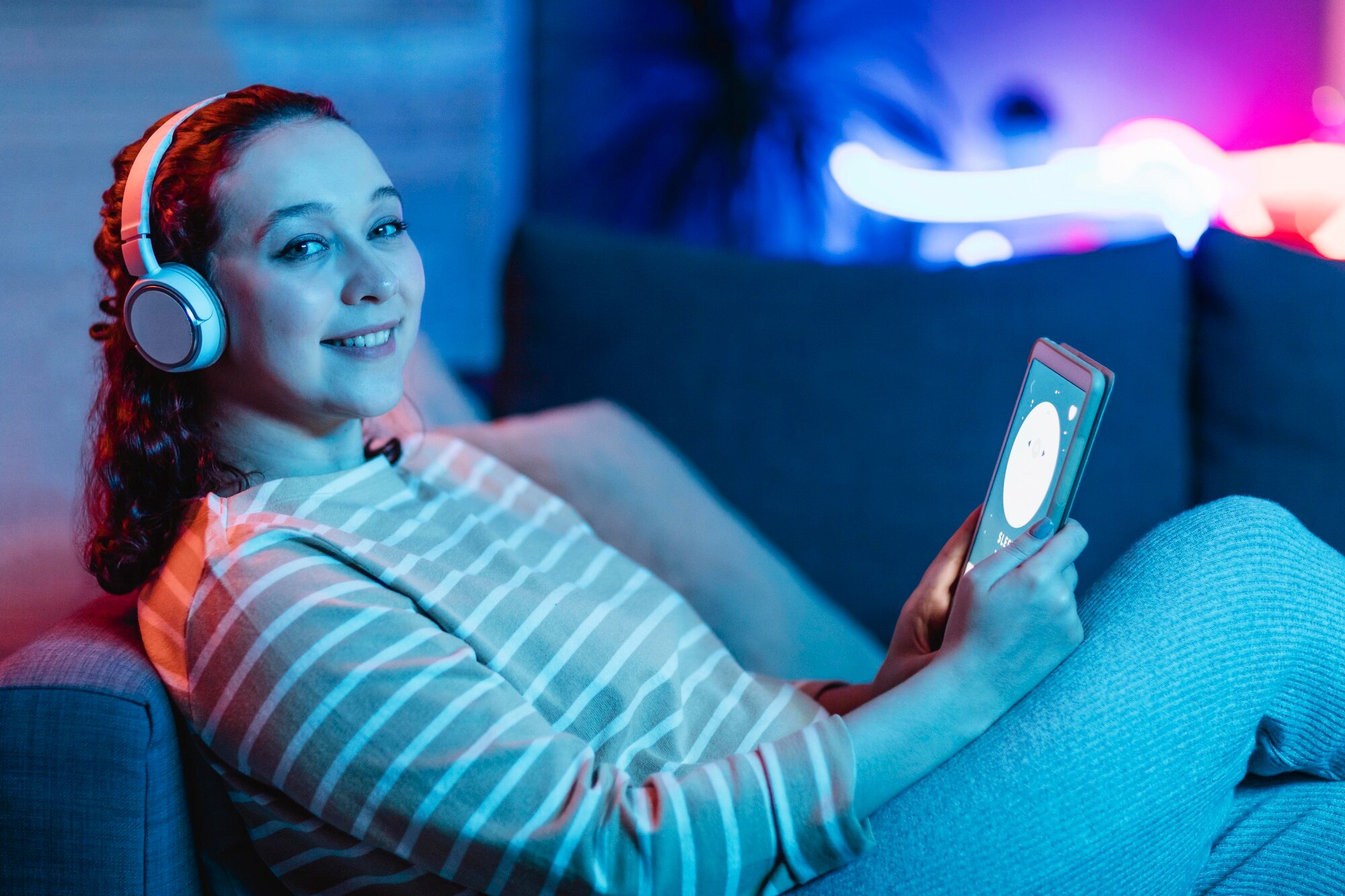 seitenansicht-der-smiley-frau-die-tablette-und-kopfhoerer-zu-hause-verwendet_23-2148793520