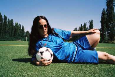 Ebow liegt auf einem Fußballfeld mit einem Ball in der Hand.