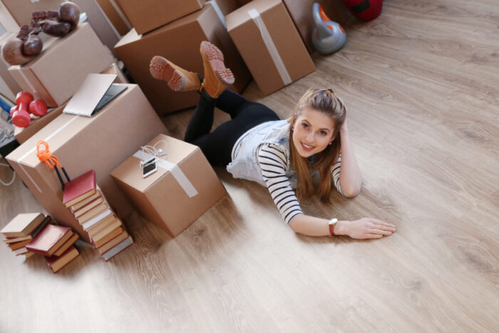 woman-finished-with-cargo-packages-is-lying-floor-smiling