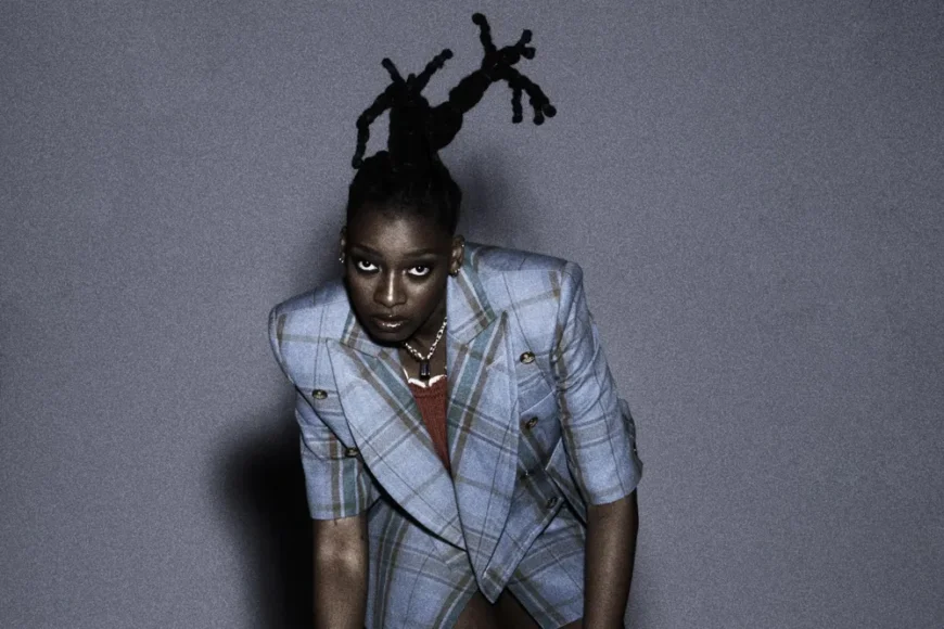 Rapperin Little Simz posiert im Anzug für die Kamera.