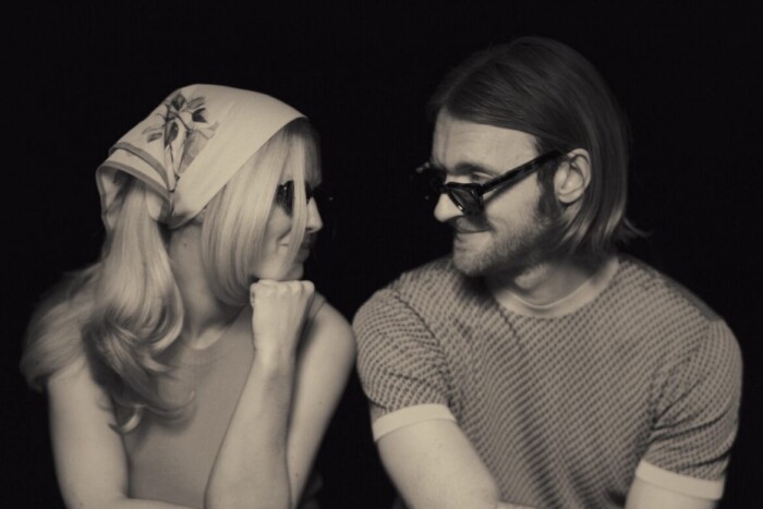 Ashe und Finneas schauen sich an, ein schwarz weiß Filter verleiht dem Foto des Duos einen Vintage-Look.