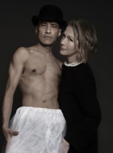 Lou Rhodes und Rohan Heath stehen nebeneinander vor einem schwarzen Hintergrund.