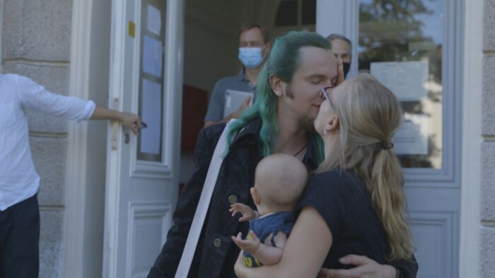 Benni und Nici küssen sich und halten ihr Baby. Sie sind eines der vier Paare die in der Doku begleitet werden.