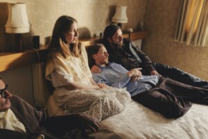 Die band Dry Cleaning liegt auf einem Bett und schaut aus dem Fenster.