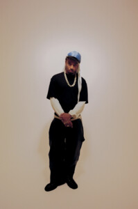 Rapper Wesley Joseph posiert vor einem weißen Hintergrund.