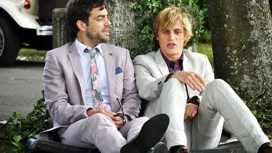 Luke und Dylan sitzen mit Anzug auf den Boden. Die Serie „Lovesick“ kann in der Arte-Mediathek gestreamt werden.