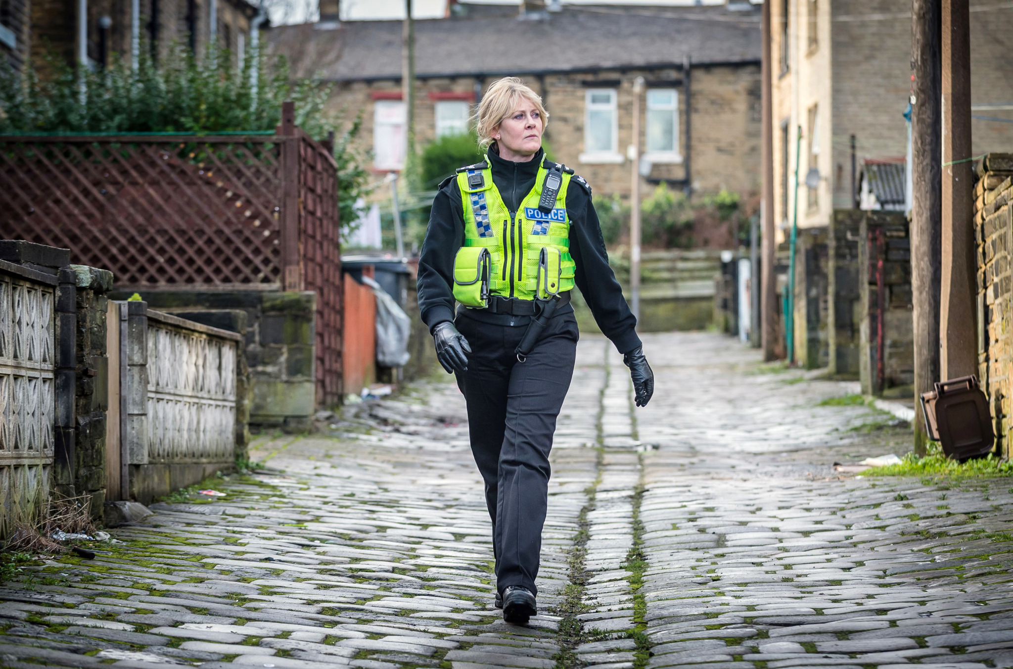 Sergeant Catherine Cawood (Sarah Lancashire) sucht die Gasse entschlossen nach einer Spur von Tommy Lee Royce (James Norton) ab.