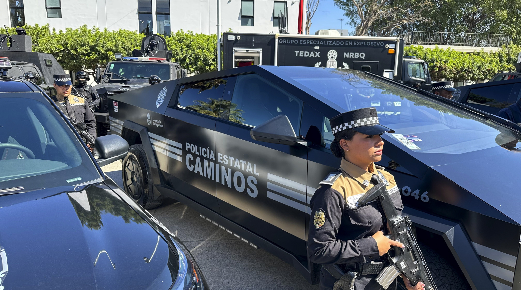 Eine bewaffnete Polizistin steht in Mexiko vor ihrem Streifenwagen.