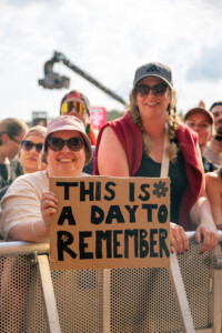 Eine Frau im Publikum hält ein Schild hoch auf dem steht: This is a Day to Remember.