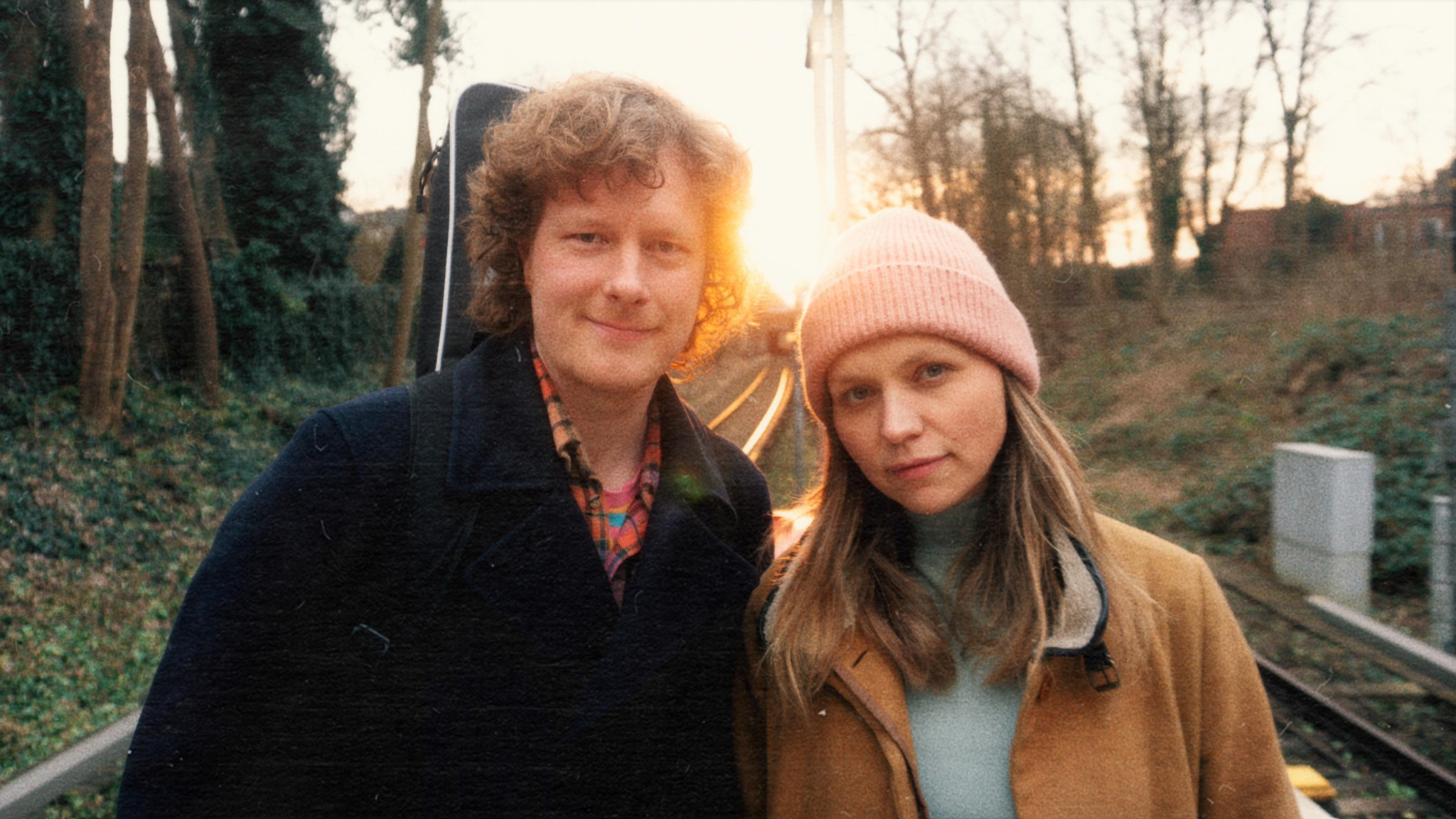 Ove Thomsen und WIM stehen nebeneinander im Freien; hinter ihnen geht die Sonne unter.