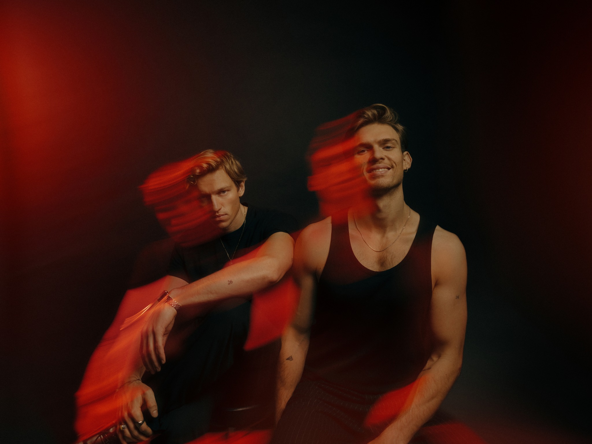 FAST BOY, alias Felix und Lucas Hain, vor dunklem Hintergrund; rotes Licht von oben links.