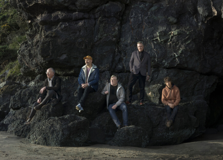 Die Mitglieder von Teenage Fanclub sitzen auf einem Felsen