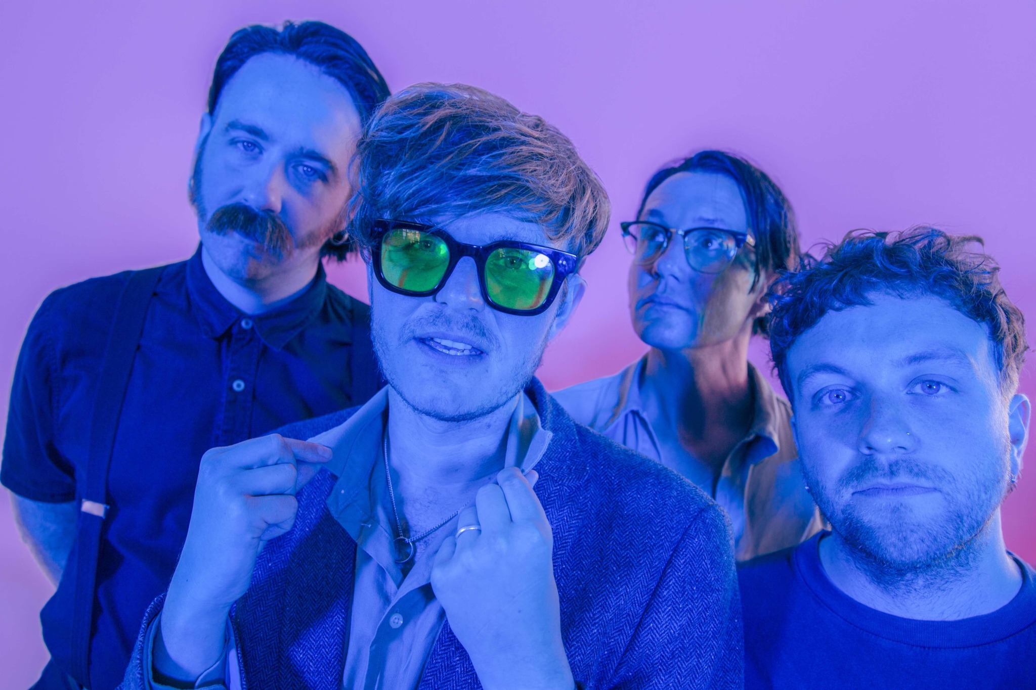 Die Mitglieder von Yard Act im Blau-Lila-Licht.