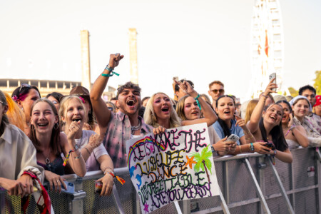 In der ersten Reihe beim Lollapalooza Berlin herrscht gute Stimmung. Fans tanzen und zeigen gebastelte Plakate.