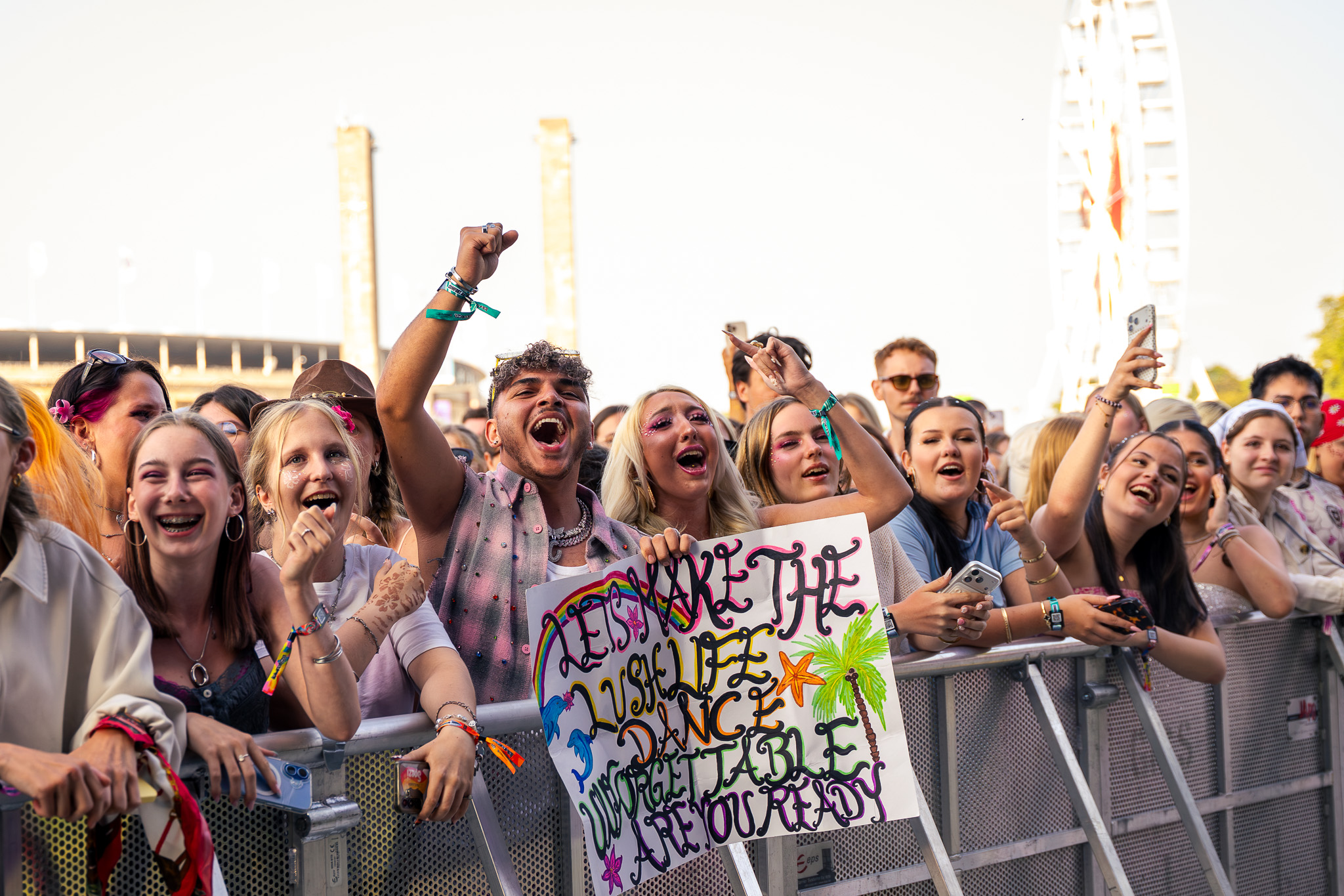In der ersten Reihe beim Lollapalooza Berlin herrscht gute Stimmung. Fans tanzen und zeigen gebastelte Plakate.
