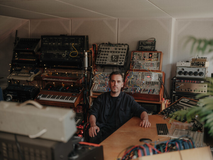 Sänger James Ellis Ford sitzt in einem Tonstudio umgeben von Technik.