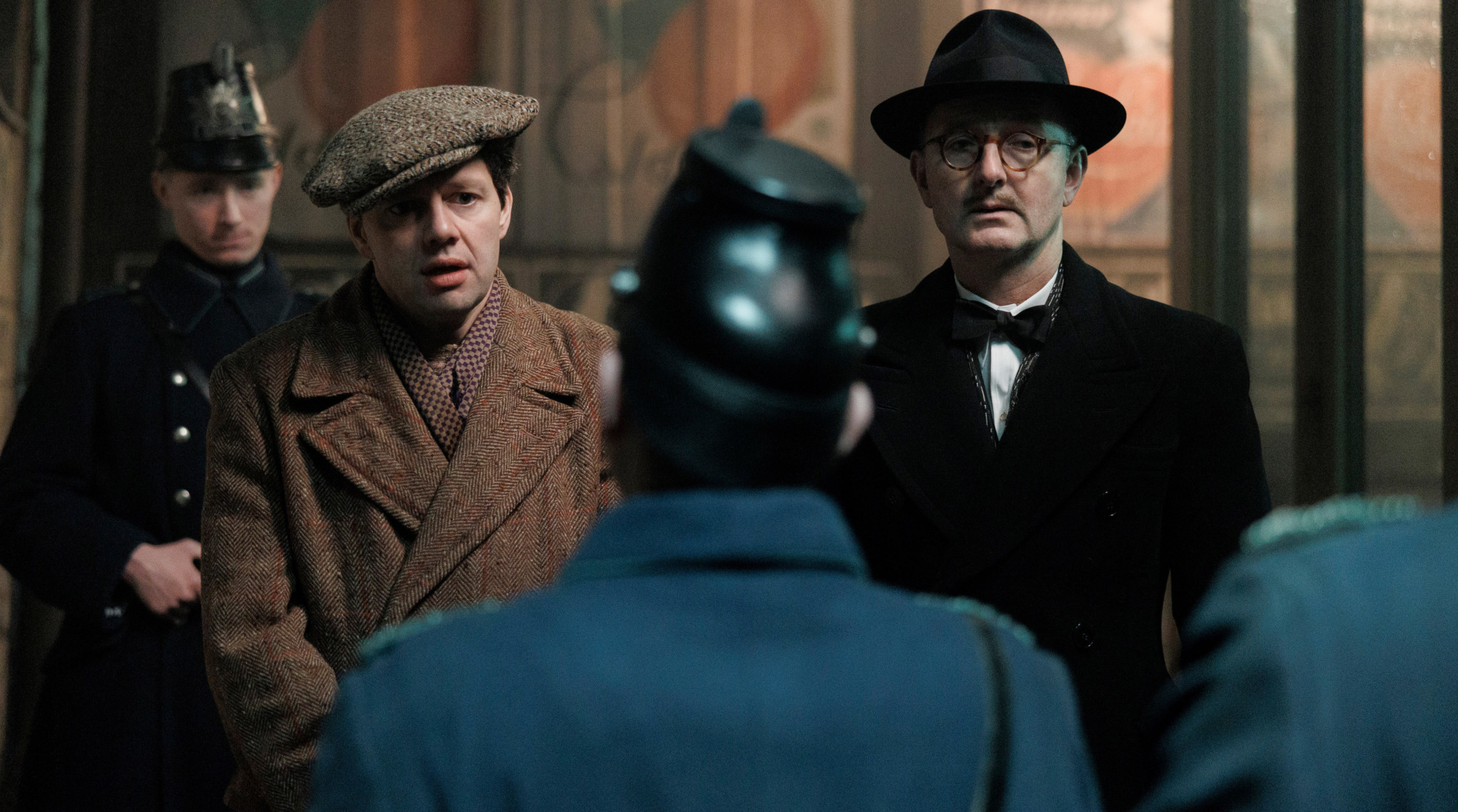 Reinhold Gräf (Christian Friedel) und sein Freund Fred Jacoby (Peter Jordan) werden vor einem queeren Klub von der SA gedemütigt. Staffel 5 der Serie „Babylon Berlin“ kann in der ARD-Mediathek gestreamt werden und läuft Mitte September im Ersten.