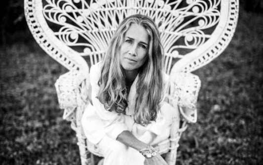 Heather Nova Sängerin sitzt im Garten auf einem Stuhl.